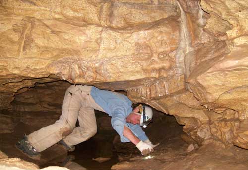 Bob Bultman 'crabwalking' over water in the cave passage